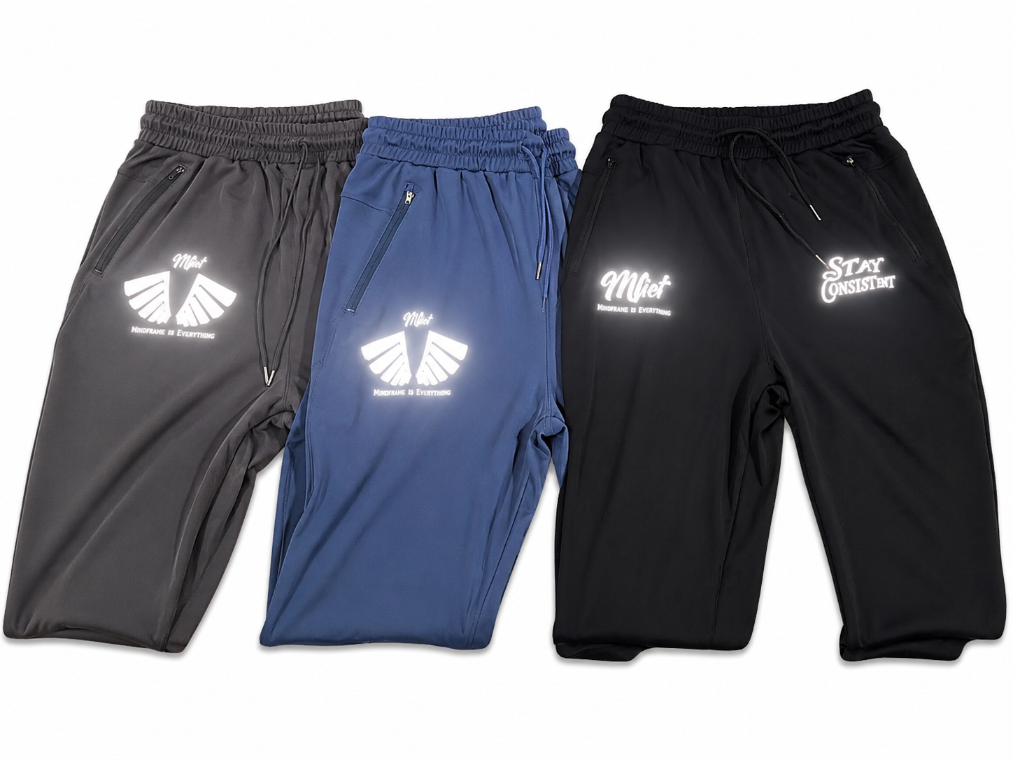 MFIET Stay Consistent performance joggers collection showing Mastermind Black, Blueprint Blue, and Clarity Grey colorways with reflective branding.